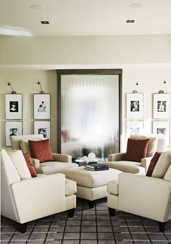 In Its Element: The focal point of the reading room is a floor-to-ceiling waterfall framed by a collection of black-and-white portraits of the couple and their triplets.