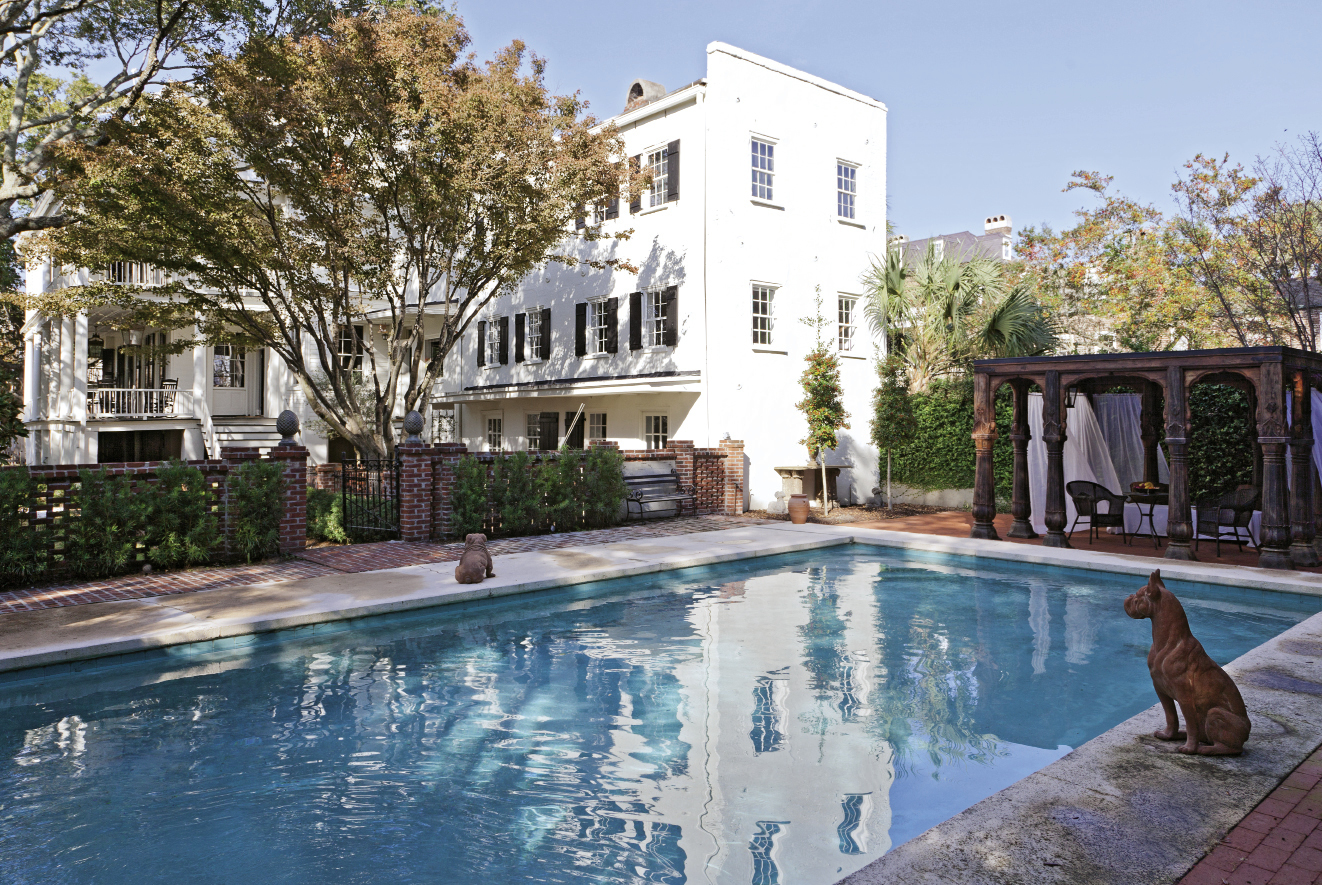 UNCOMMON GROUNDS A carved teak pergola stands at the far end of the pool, which is located in what once was the property’s stableyard.