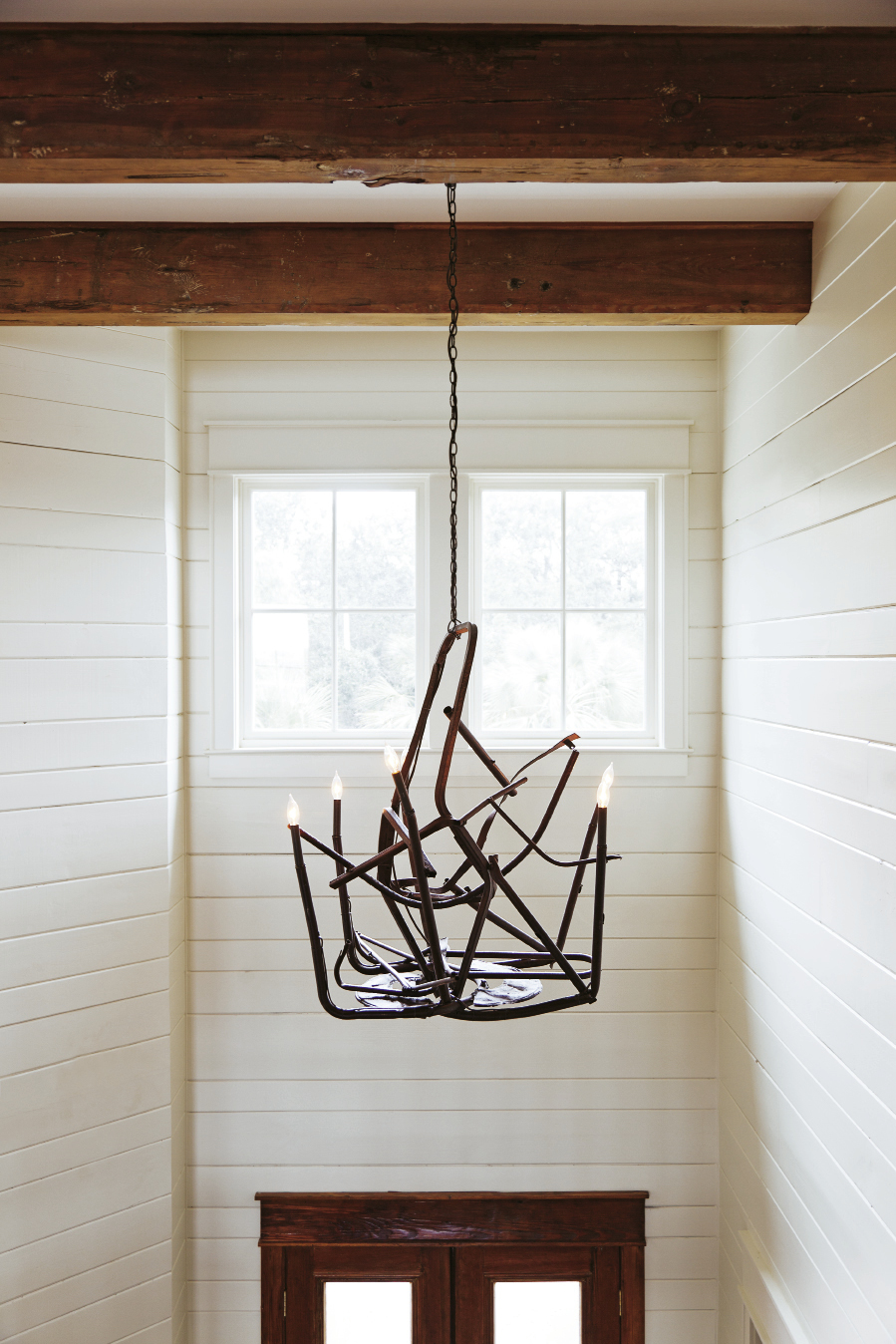 ; a College of Charleston art student crafted the metal from chairs melted in the Bowen’s Island restaurant fire into a chandelier that hangs in the front foyer