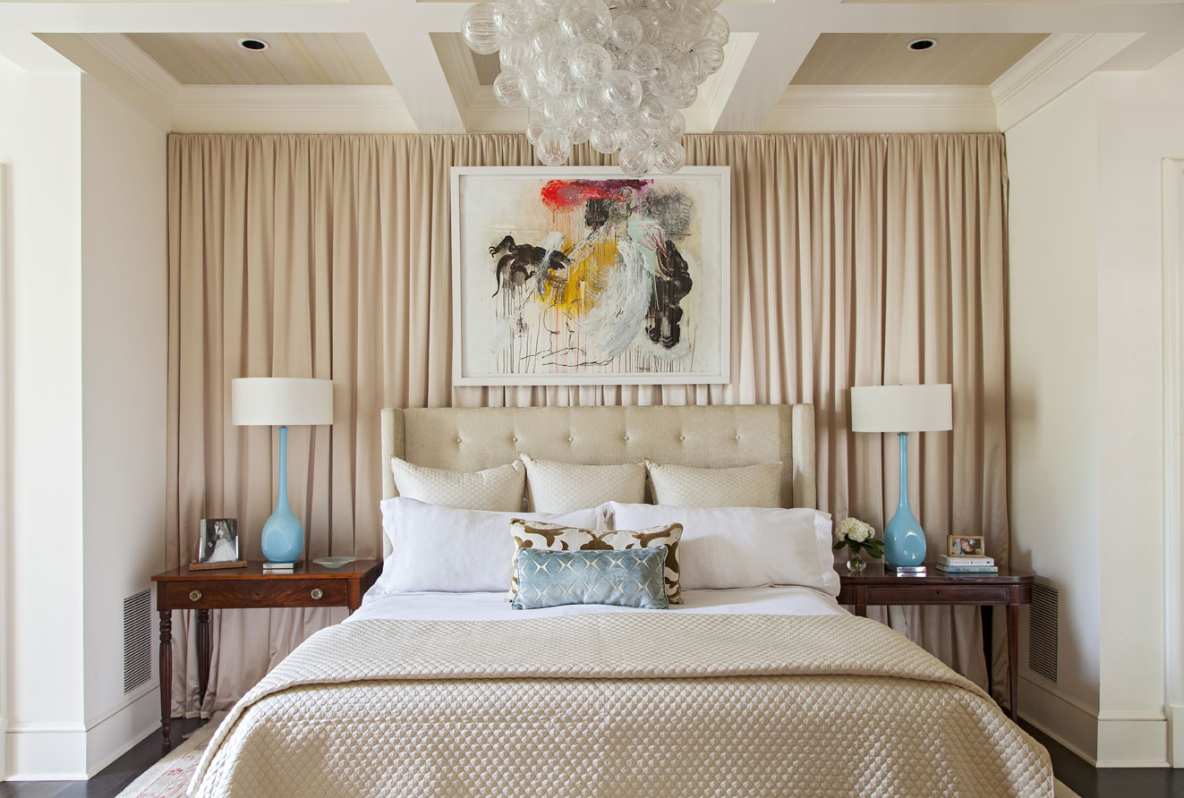 Above the bed, a sculptural chandelier hangs near a colorful abstract piece by local artist Tim Hussey.