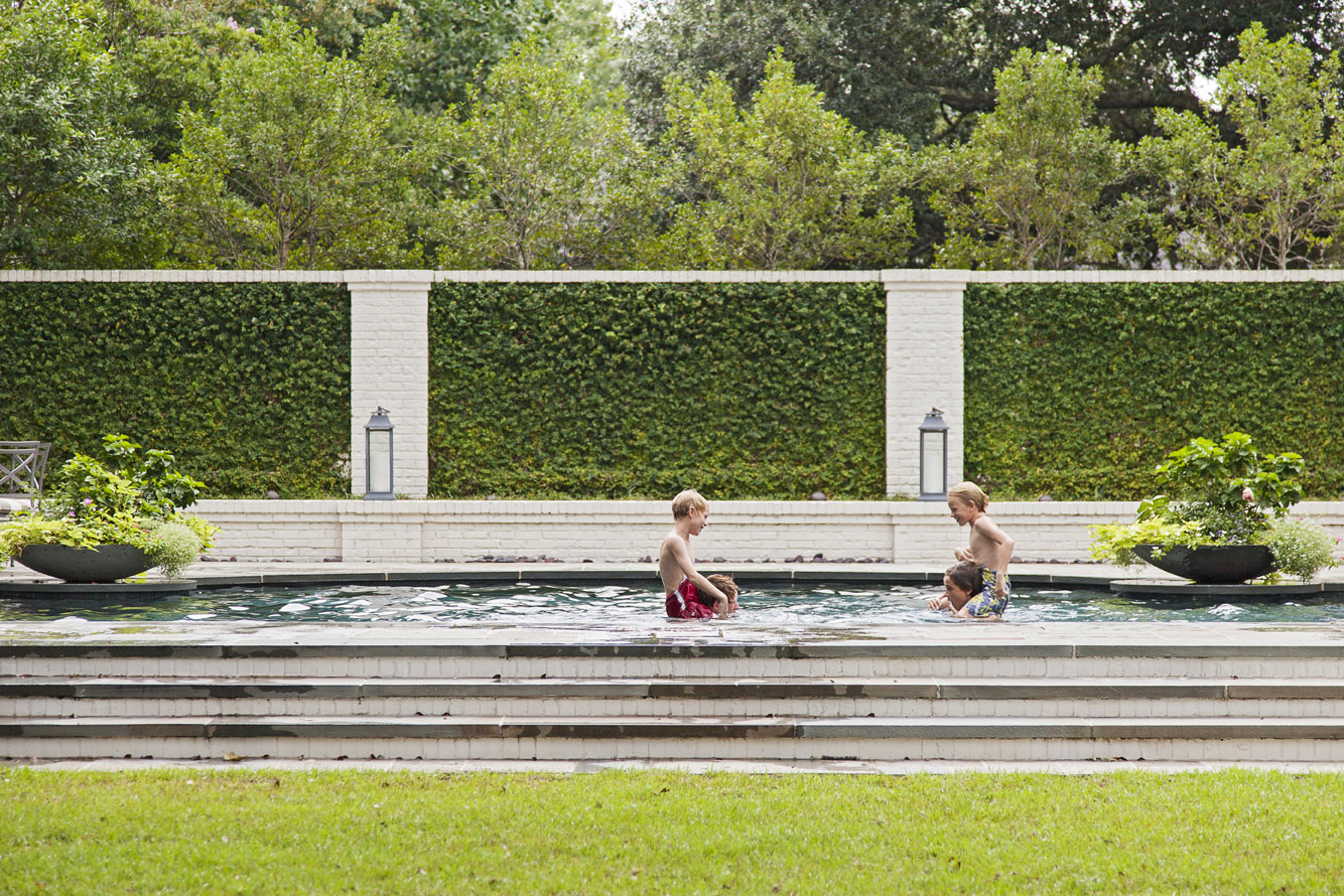 CABANA COOL: Elevated pool cabanas provide shade and a place to relax (top). A landscaped brick wall acts as a privacy screen as the Hastings boys face off in the pool for a game of chicken.
