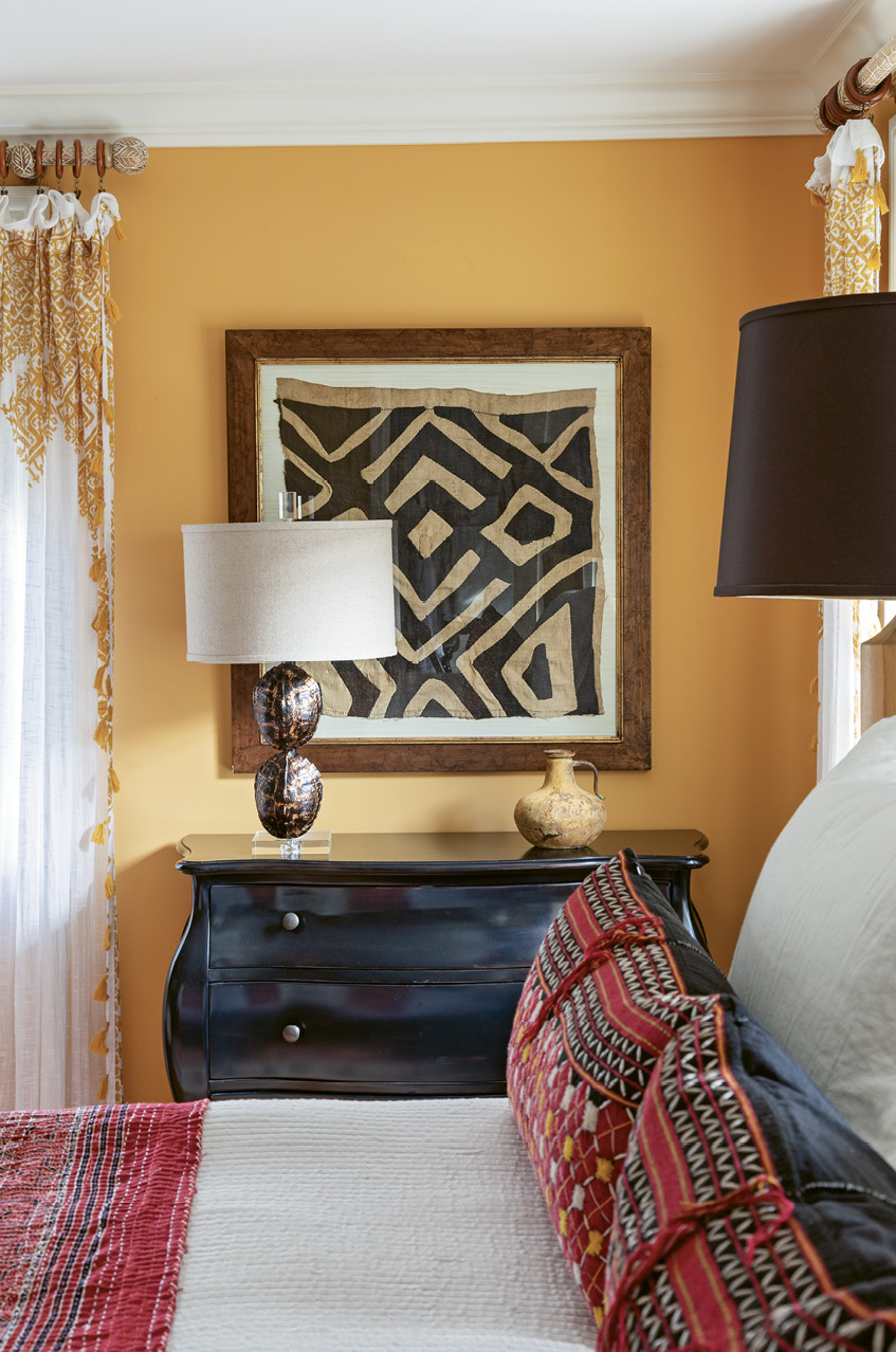 Upstairs, a snug bedroom suite entices with walls painted in “Orangerie” by Farrow and Ball.