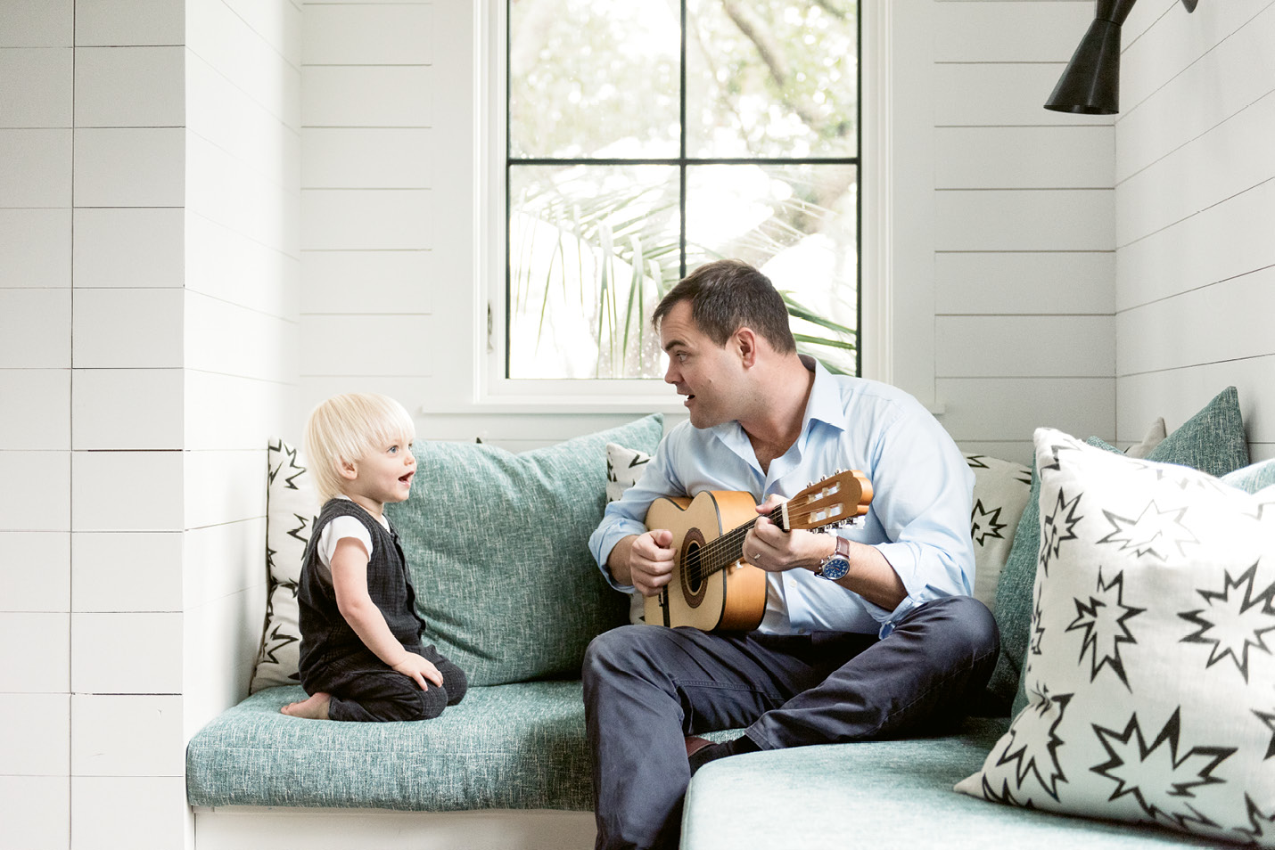 Ted serenades Fox in the nursery amongst pillows upholstered in playful comic book-inspired fabric.
