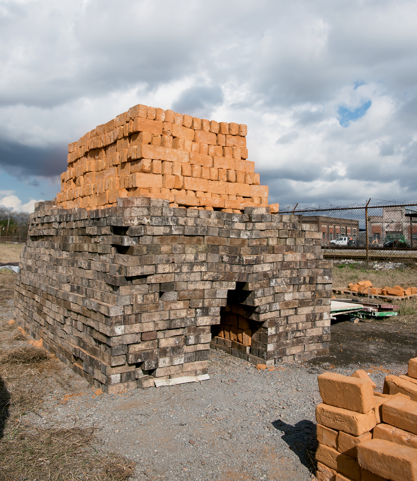 During the Colonial period, bricks were often produced using a clamp kiln built temporarily on each job site. This winter, Tidewater Brick Co. fired its first batch of raw bricks in a clamp (shown here still in progress) at 1630 Meeting Street.