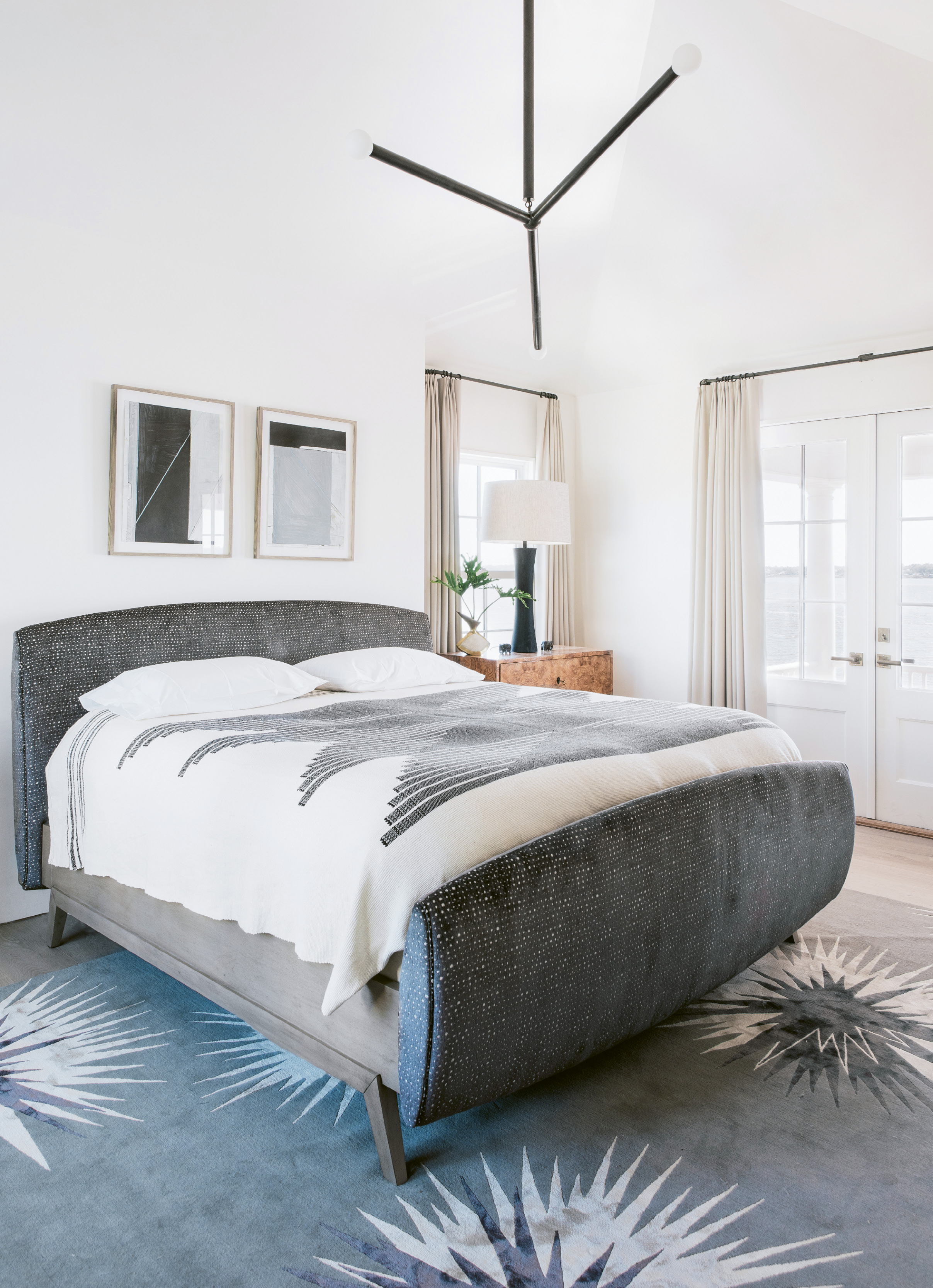 In the master suite, vaulted ceilings soar over a plush bed by Habel for Hickory Chair; a burl-wood chest adds unexpected warmth.