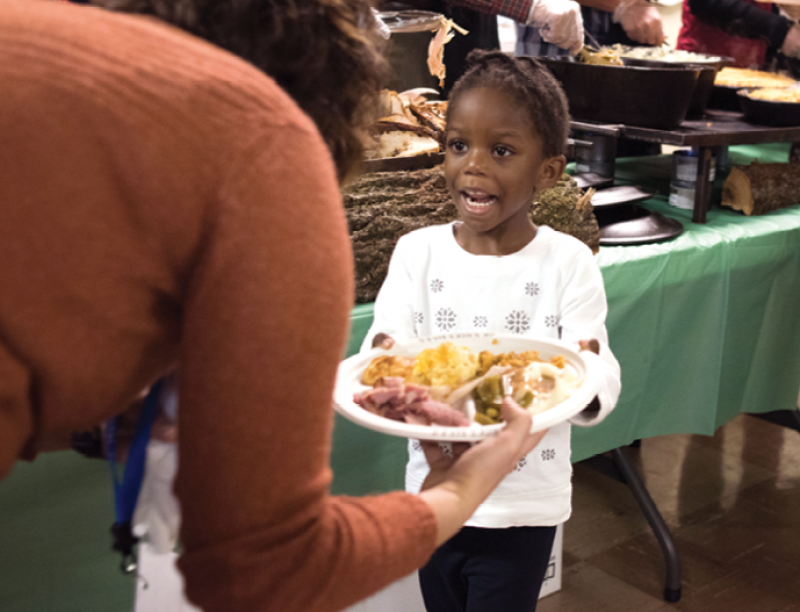 A young girl accepts a plate loaded up by Feed the Need. Want to lend a hand? Contact Bakst at <a href="mailto:mickey.bakst@belmond.com">mickey.bakst@belmond.com</a>.