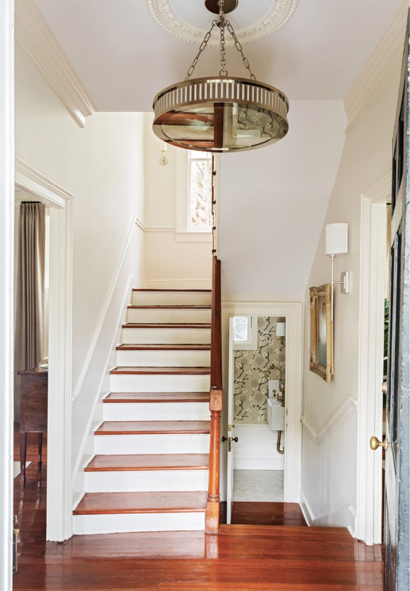 The entry hall also features a dramatic Urban Electric chandelier, hanging from a restored 18th-century ceiling medallion above original heart-of-pine floors.