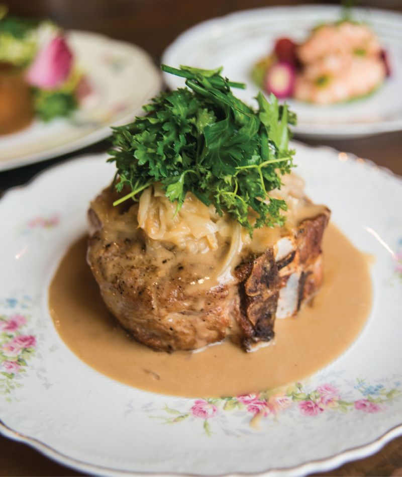 Some Chops: Bathed in a classic French mustard sauce, the grilled pork porterhouse gets dressed with melted onions and a leafy herb salad.