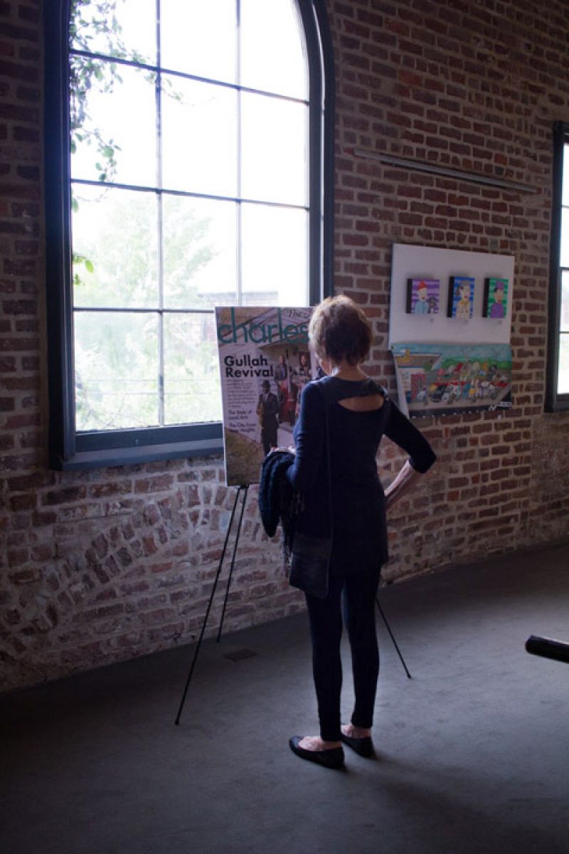 A guest admires Charleston magazine’s May cover, featuring Quiana Parler and Charlton Singleton with their band, Ranky Tanky.