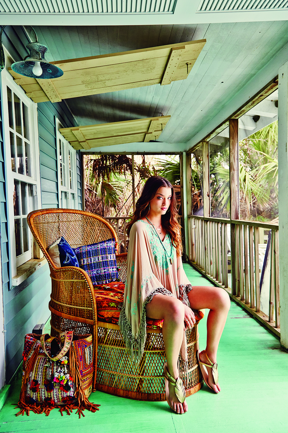 Miss June poncho, $168 at Lori + Lulu; Robin Haley gold loop earrings, $105 at Shirtini; Kate Davis “Sandbar” necklace with mother-of-pearl and 14K gold-fill plate, $92 at katedavisjewelry.com; Birdsong Design “Sleeping Beauty” turquoise cluster necklace, $45 at Birdsong Design Studio; Peyton William turquoise and tiger eye necklace, $125 at Peyton William; Corso Como “Edgar” sandals, $88 at Copper Penny Shooz; and artisan fringe tote, $295 at Calypso. Props: rattan chair from Charleston Revisions, pillows and blanket from IBU